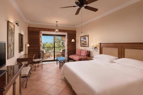 a hotel room with a bed and a balcony at Sheraton Fuerteventura Golf & Spa Resort in Caleta De Fuste