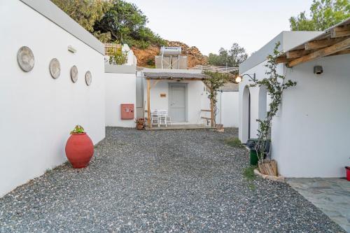 a white house with a red vase on the side of it at Anassa Cycladic Village in Galissas