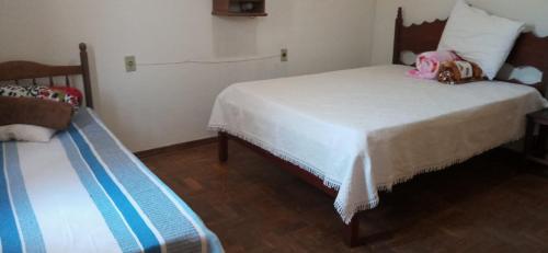 1 Schlafzimmer mit 2 Betten und einer Bank in der Unterkunft Canastra de Minas casa para temporada in São Roque de Minas