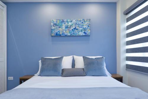 ein blaues Schlafzimmer mit einem Bett mit blauen Wänden in der Unterkunft The Cozy Condo in Arouca