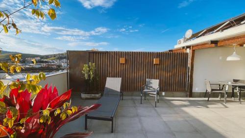 a patio with a table and chairs on a balcony at Hotel Amantykir in Itajubá