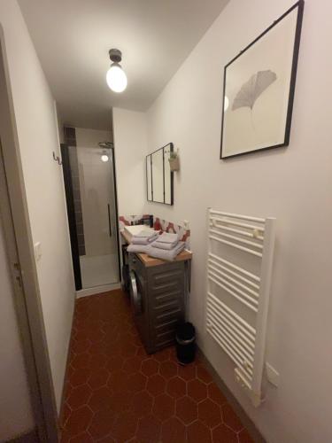 Cette chambre comprend un bureau et un miroir. dans l'établissement Le Petit Pilat - Studio de charme en hyper centre avec climatisation, à Avignon