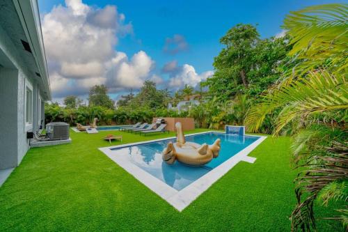 a pool with a dog float in the middle of a yard at Luxury Duplex in Heart of Fort Lauderdale Near The Beach in Fort Lauderdale