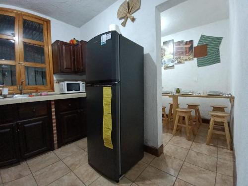 a black refrigerator in a kitchen with a table at Casa Aguacate in Antigua Guatemala