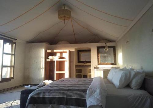 a bedroom with a large bed in a room at Desert Luxury Camp in Mhamid