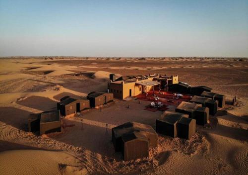 a small village in the middle of a desert at Desert Luxury Camp in Mhamid