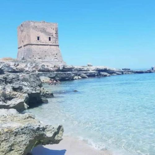 a lighthouse on the shore of a beach at Grotta dei Puntali B&B in Carini