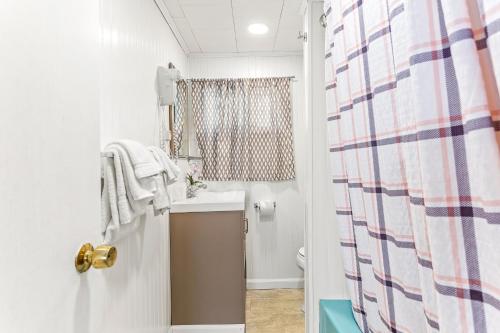 a bathroom with a sink and a shower curtain at Tides Motel - Hampton Beach in Hampton