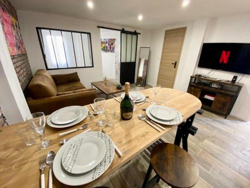 a wooden table with plates and a bottle of wine at Villa Heritage in Beausoleil