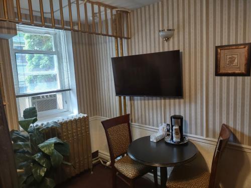 a hotel room with a table and a television at The King George Inn in Cobourg