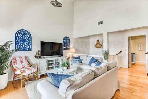 a living room with a white couch and a tv at 8 Sea Castles condo in Fernandina Beach