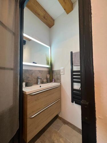une salle de bain avec un lavabo et un miroir dans l'établissement Duplex meublé face aux arènes d'ARLES, à Arles