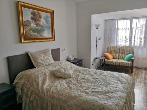 een slaapkamer met een bed en een stoel bij Apartamento Cuatro Caminos Calpe in Calpe