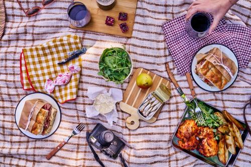 a picnic table with plates of food and a glass of wine at Dawn Ranch in Guerneville