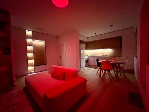 ein Wohnzimmer mit einem roten Sofa und einer Küche in der Unterkunft Lizz Panoramic Residence in Floreşti