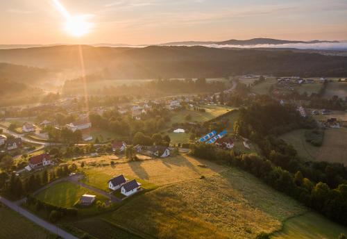 an aerial view of a village in the mountains with the sun setting at Domki Zielone Wzgórze 606-819-046 in Polańczyk