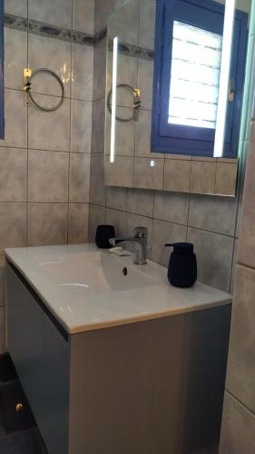 La salle de bains est pourvue d'un lavabo et d'une fenêtre. dans l'établissement Veranda to Aegean, à Ligia