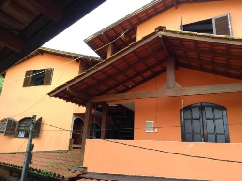 una casa naranja con ventanas y techo en Pousada João e Maria en Trindade