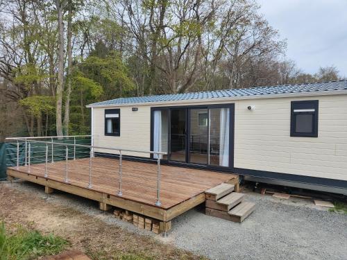 une petite maison assise sur une terrasse en bois dans l'établissement Le Colorful, à Dinard