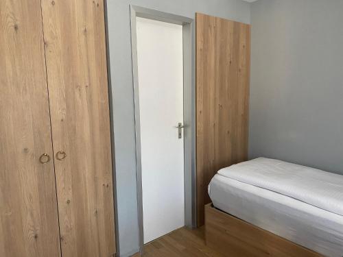 a small bedroom with a bed and a closet at Louis Hotels in Schmitten