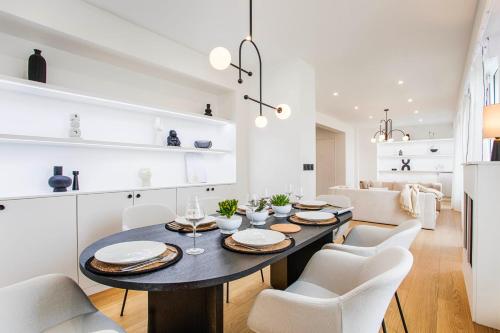 une salle à manger avec une table noire et des chaises blanches dans l'établissement Le Kennedy - Sublime 3 bedrooms Duplex in Trouville, à Trouville-sur-Mer