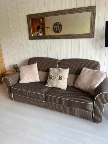 a couch with two pillows on it in a room at Tignes le Lac - Appartement au pied des pistes in Tignes
