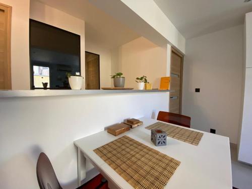 une salle à manger avec une table et des chaises blanches dans l'établissement Sunsète appartement T3 duplex centre ville avec terrasse et balcon, à Sète
