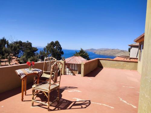 Un balcón con 2 sillas y una mesa con vistas. en Hosteria LAS ISLAS, en Comunidad Yumani