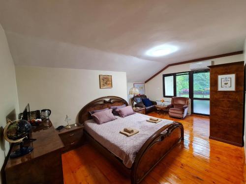 ein Schlafzimmer mit einem großen Bett und Holzboden in der Unterkunft Villa Janet in Dolna Banya