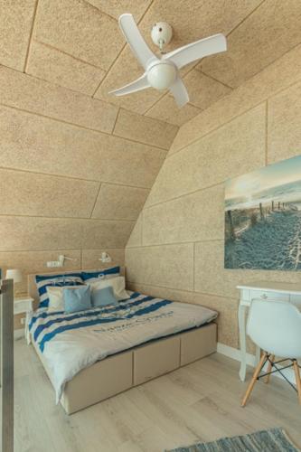 a bedroom with a ceiling fan and a bed at Summer House-Nowoczesne domki z jacuzzi i ładowarką do samochodu in Wrzosowo