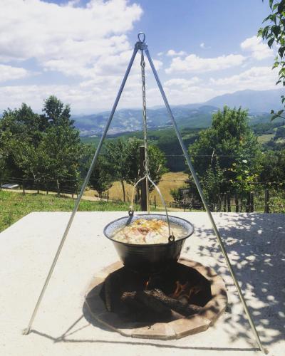a bowl of food is hanging over a fire at Seosko domacinstvo Becirovic - Kukulik lodgings in Bijelo Polje