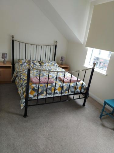 a black bed in a room with a window at Atrium Apartment A in Bangor