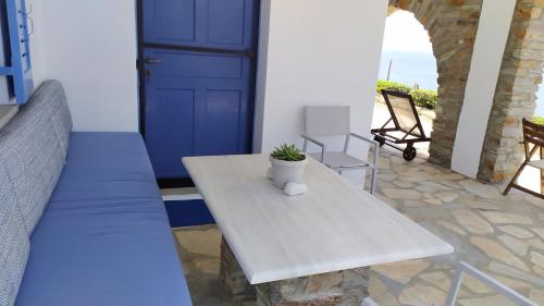 een veranda met een tafel en een blauwe deur bij Veranda to Aegean in Ligia