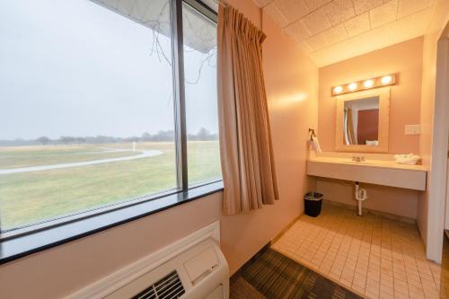 a bathroom with a large window and a sink at Candlestone Golf and Resort in Belding