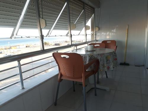 een eetkamer met een tafel en stoelen en uitzicht op het strand bij SARIMSAKLI PLAJINA 0 METRE DENİZ MANZARALI LÜX DAİRE in Ayvalık