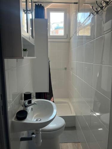 une salle de bain blanche avec un lavabo et des toilettes dans l'établissement Joli appart à 10 minutes de Paris en métro - Parking Offert, à Saint-Ouen