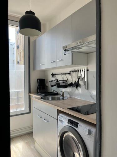 une cuisine avec un évier et une machine à laver dans l'établissement Joli appart à 10 minutes de Paris en métro - Parking Offert, à Saint-Ouen