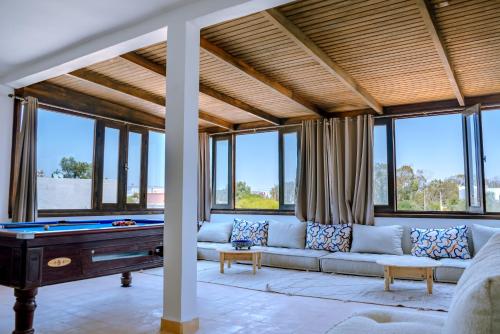 un soggiorno con un divano e un tavolo da biliardo di villa Floratus a Essaouira