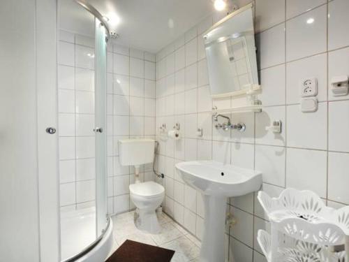 ein weißes Bad mit einem WC und einem Waschbecken in der Unterkunft Gospodarstwo agroturystyczne Pod Świerkami in Berezka
