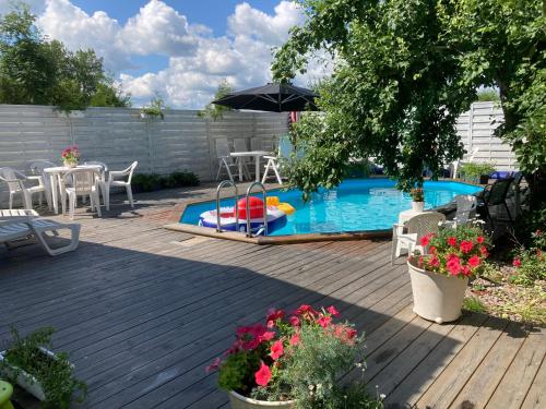 uma piscina com uma mesa e cadeiras e um guarda-sol em Mehri em Uppsala