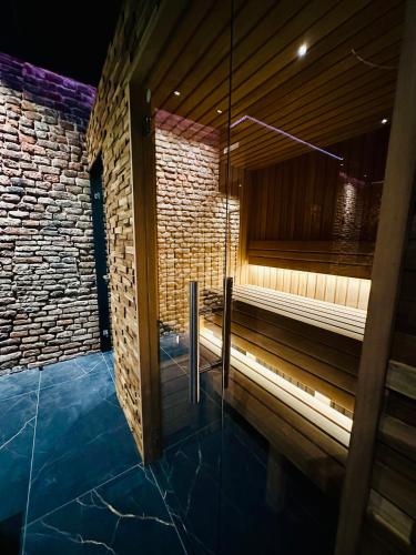 a sauna with a brick wall and a glass door at Hotel de Prince in Nijmegen