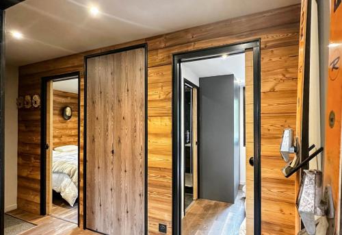 una camera con pareti in legno e una porta con una camera da letto di Masai Megeve a Megève