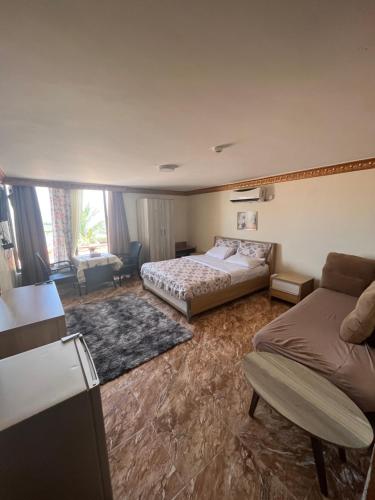 a hotel room with a bed and a couch at Al-Amer Chalets in Aqaba