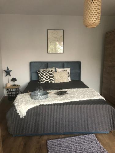 a bedroom with a large bed with a gray headboard at Apartament Impresja II in Rowy