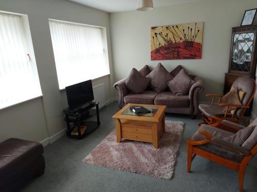 a living room with a couch and a coffee table at The Plaza Suites High St Bangor in Bangor