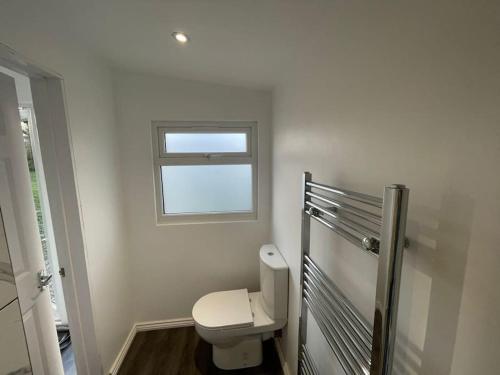 a bathroom with a toilet and a window at The Cabin in Welwyn Garden City