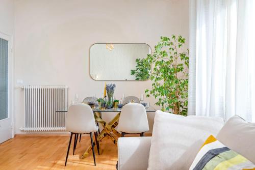 a living room with a table and two white chairs at Art Deco' - Sleepwithme - Free Parking - Free Breakfast - Very Friendly Staff in Pisa