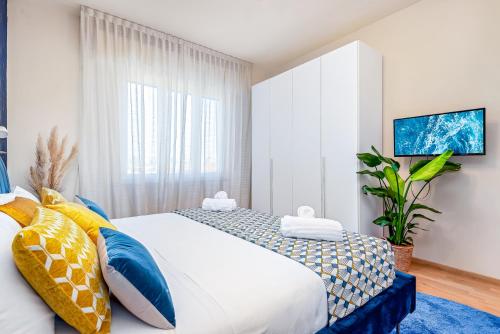 a bedroom with a bed with blue and yellow pillows at Art Deco' - Sleepwithme - Free Parking - Free Breakfast - Very Friendly Staff in Pisa
