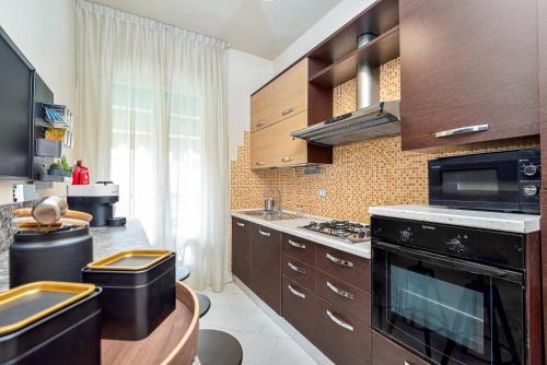 a kitchen with wooden cabinets and a stove top oven at Art Deco' - Sleepwithme - Free Parking - Free Breakfast - Very Friendly Staff in Pisa