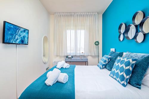 a blue bedroom with towels on a bed at Art Deco' - Sleepwithme - Free Parking - Free Breakfast - Very Friendly Staff in Pisa